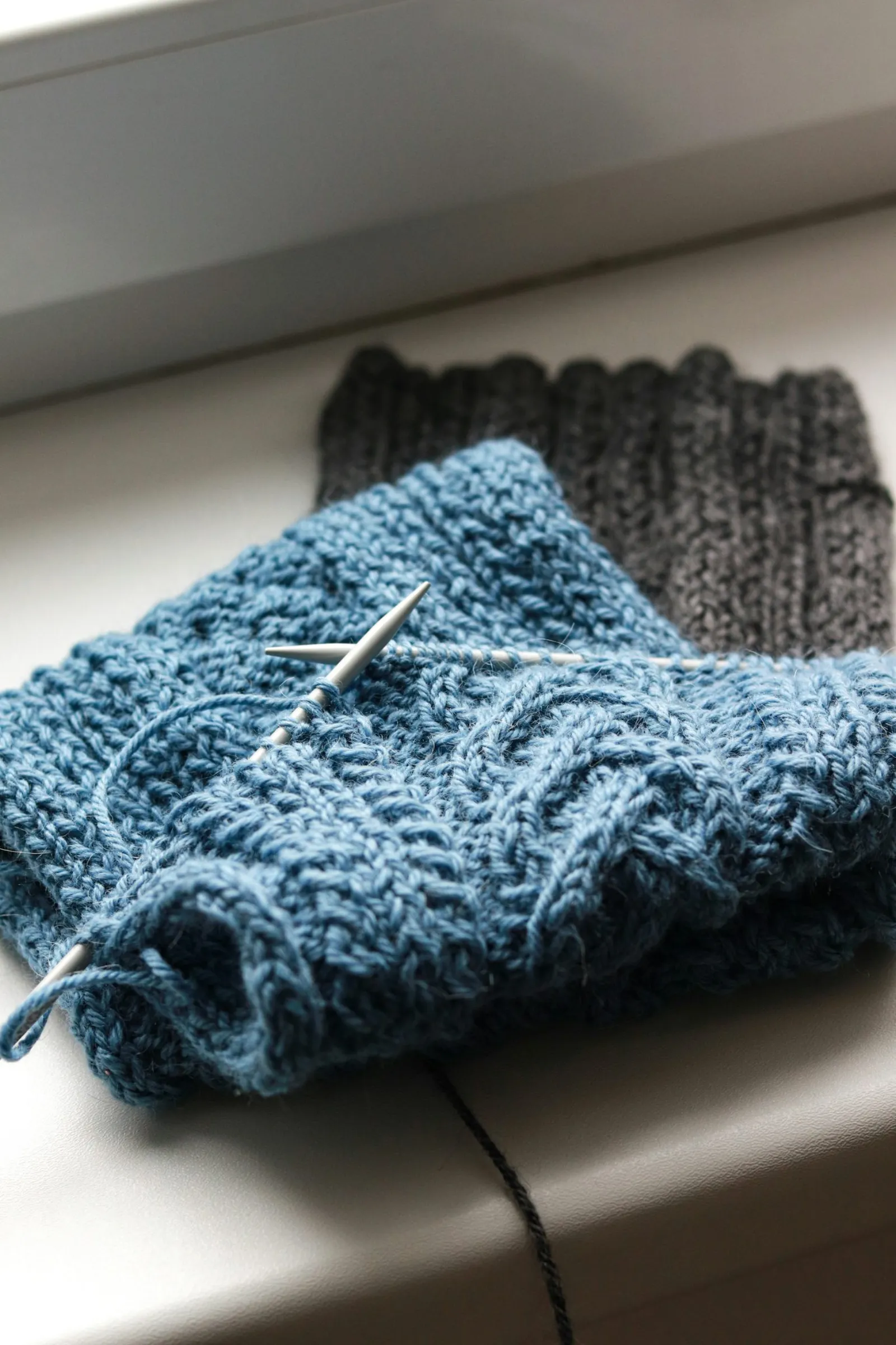 A blue cable knit on a circular needle