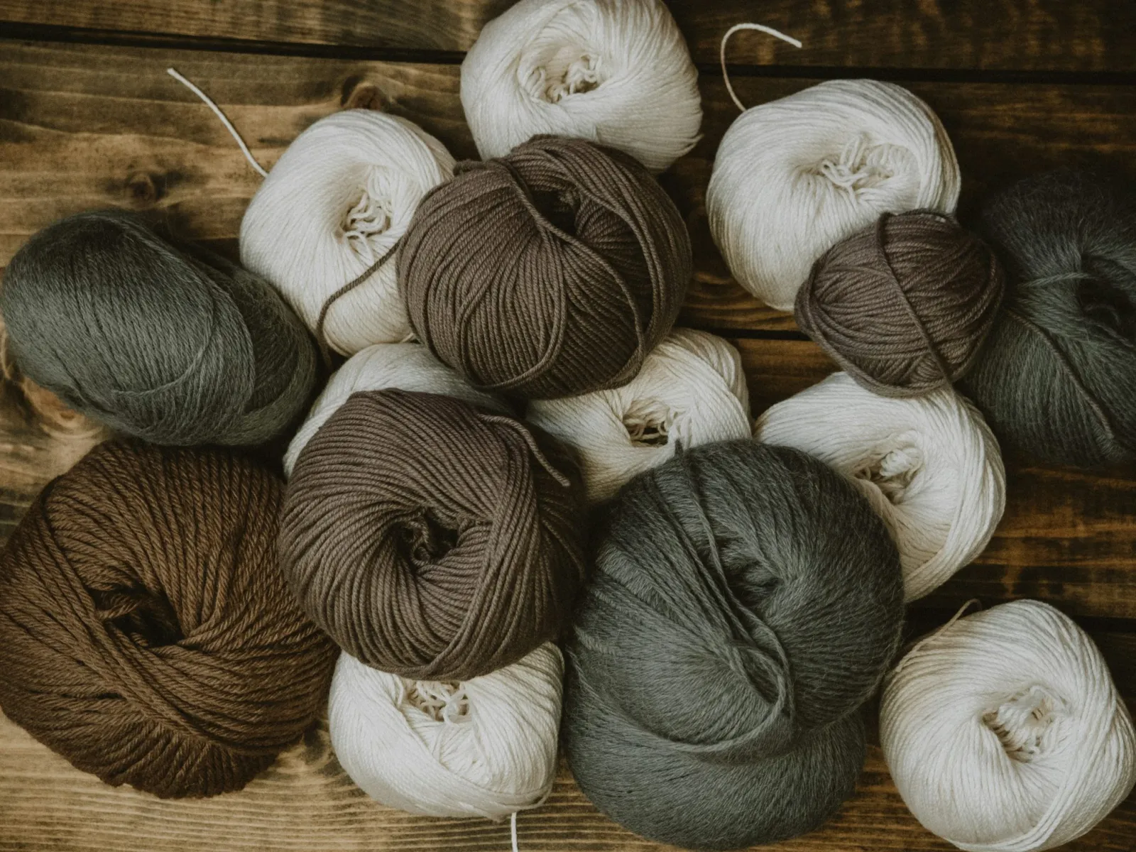Undyed brown, grey and cream skeins of yarn
